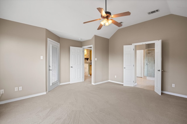 unfurnished bedroom with ceiling fan, light colored carpet, lofted ceiling, and ensuite bathroom