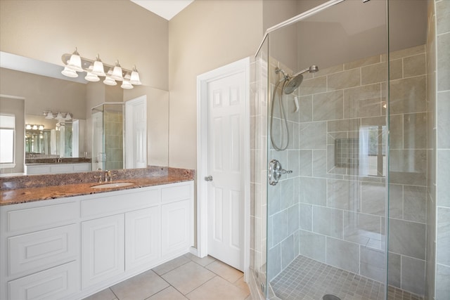 bathroom featuring tiled shower, vanity, and tile patterned floors