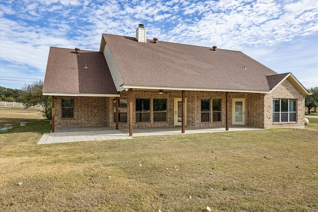 back of house featuring a lawn and a patio