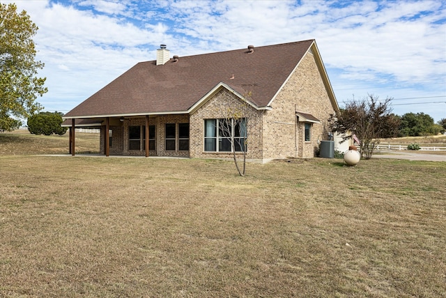 rear view of house with a lawn and cooling unit