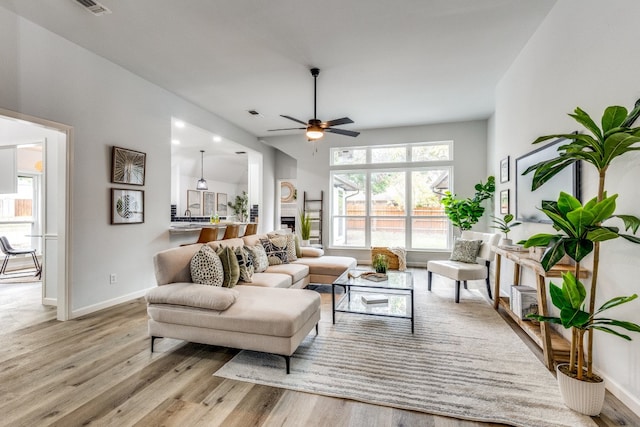 living room with ceiling fan and light wood-type flooring