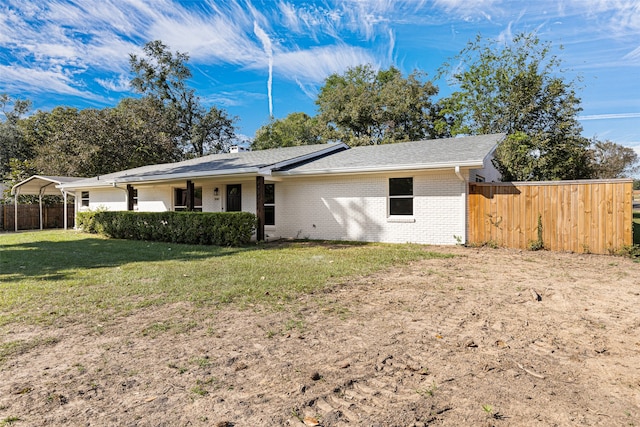 view of front of property featuring a front lawn and a carport