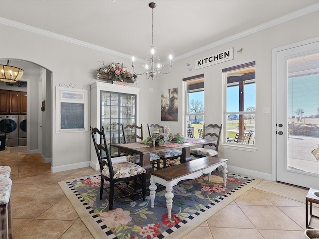 tiled dining area with a chandelier, ornamental molding, and washing machine and clothes dryer