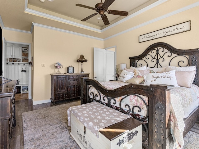 bedroom featuring a raised ceiling, ceiling fan, dark hardwood / wood-style floors, and ornamental molding