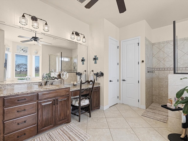 bathroom with tiled shower, vanity, and tile patterned floors