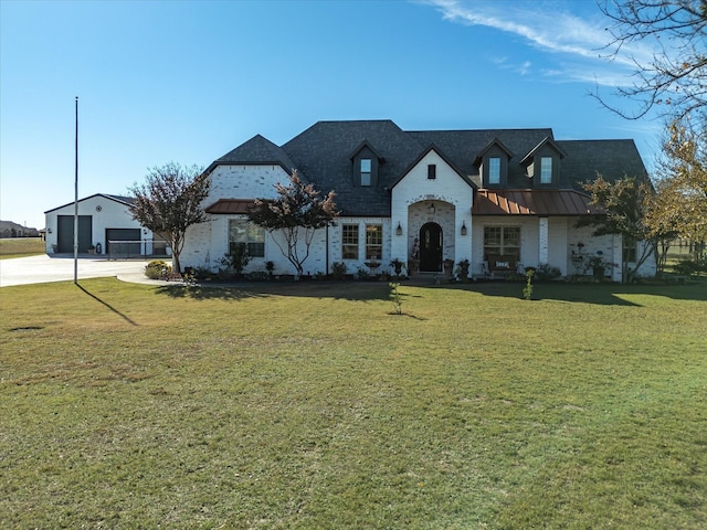 view of front of house with a garage, an outdoor structure, and a front lawn