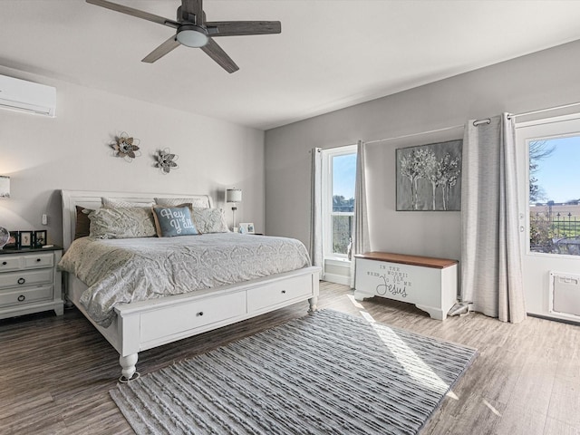 bedroom featuring dark hardwood / wood-style floors, ceiling fan, and a wall mounted AC