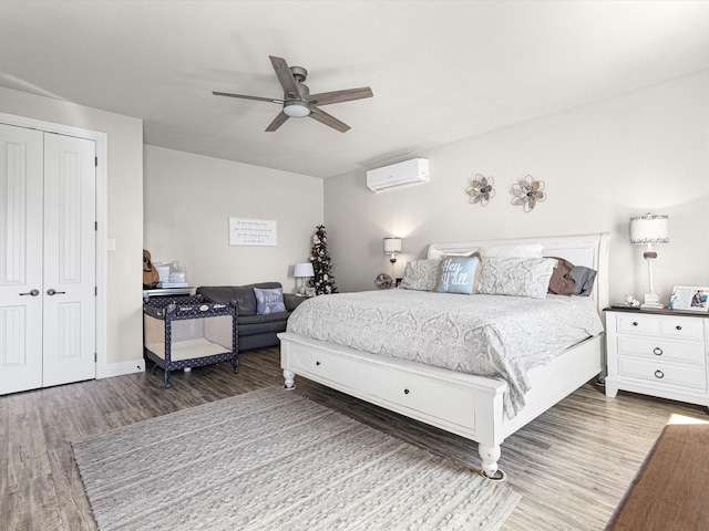 bedroom featuring an AC wall unit, ceiling fan, a closet, and wood-type flooring