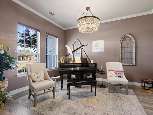 sitting room with wood-type flooring, an inviting chandelier, and ornamental molding