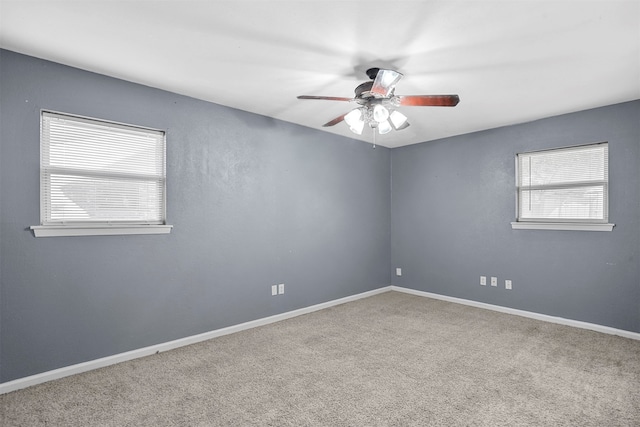 carpeted spare room with ceiling fan