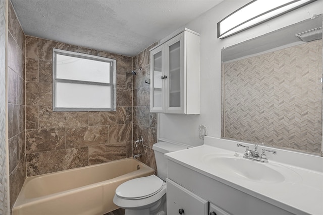 full bathroom featuring a textured ceiling, vanity, toilet, and tiled shower / bath