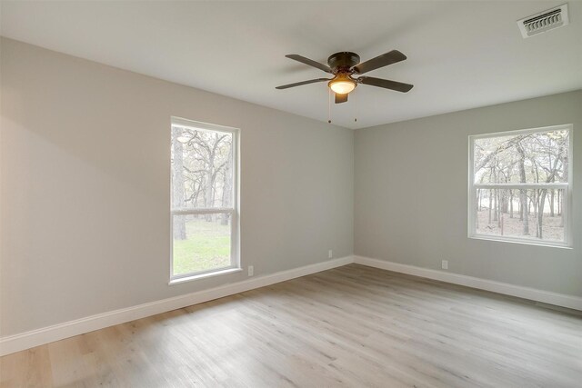 unfurnished room with ceiling fan, plenty of natural light, and light wood-type flooring