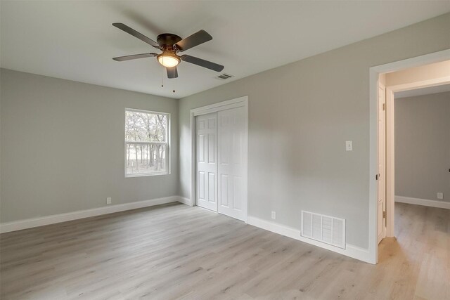 unfurnished bedroom with a closet, light hardwood / wood-style floors, and ceiling fan