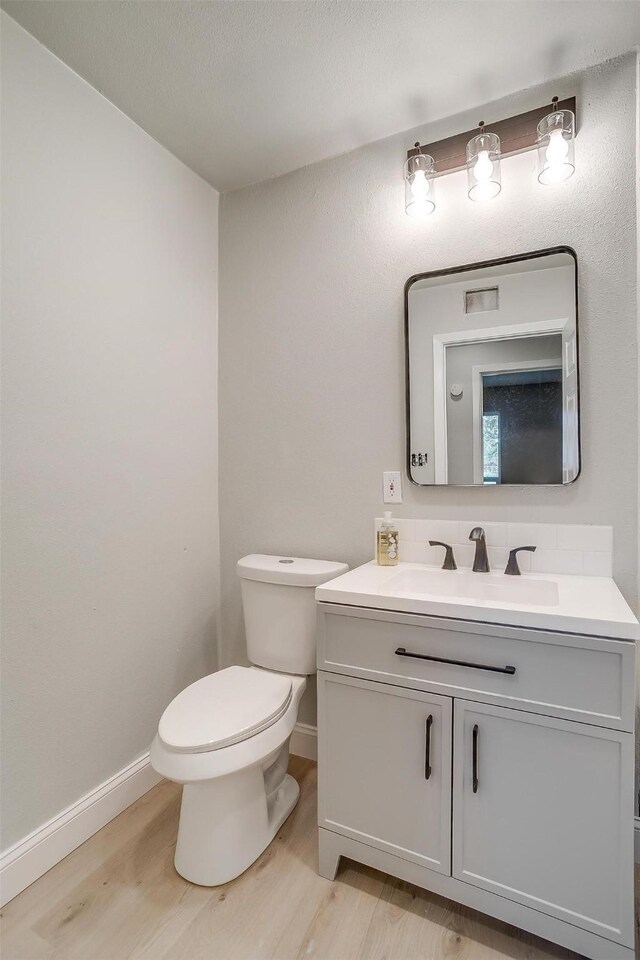 bathroom with vanity, hardwood / wood-style flooring, and toilet