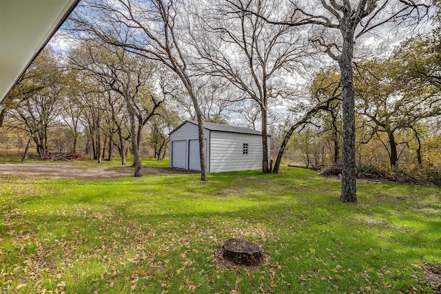 view of yard with a garage and an outbuilding