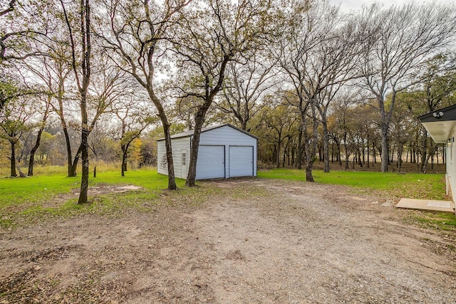 view of yard with a garage and an outbuilding