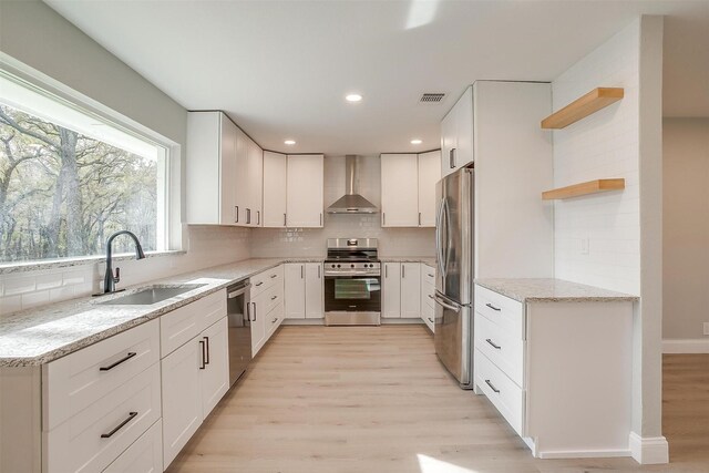 kitchen featuring white cabinets, sink, wall chimney exhaust hood, and stainless steel appliances