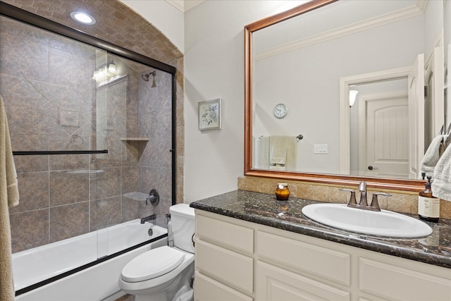 bathroom featuring toilet, bath / shower combo with glass door, crown molding, and vanity