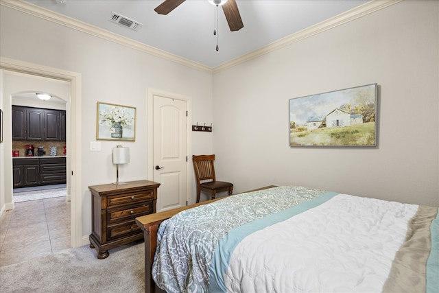 bedroom with ceiling fan, light colored carpet, crown molding, and connected bathroom