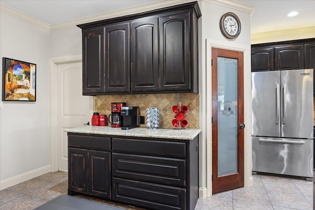 kitchen with ornamental molding, freestanding refrigerator, backsplash, and light tile patterned floors