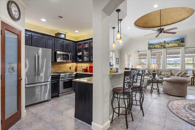 kitchen featuring a breakfast bar area, stainless steel appliances, tasteful backsplash, visible vents, and light tile patterned flooring