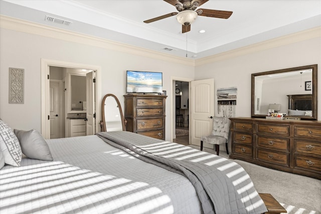 carpeted bedroom with a tray ceiling, visible vents, and crown molding