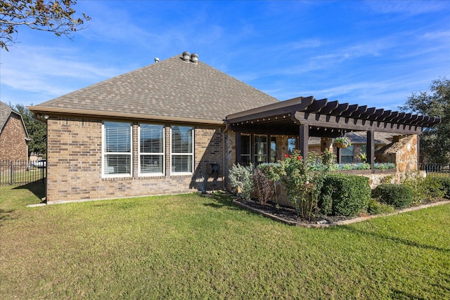 back of house featuring roof with shingles, a yard, brick siding, fence, and a pergola