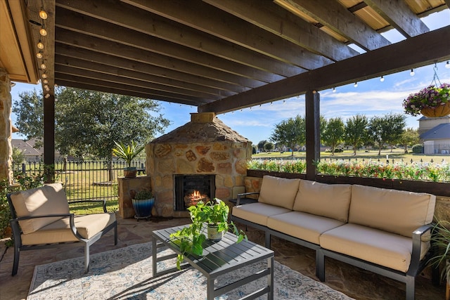 view of patio with fence and an outdoor living space with a fireplace