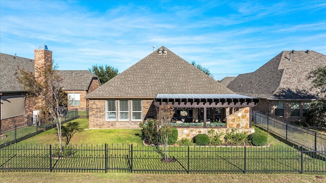 rear view of property with brick siding, a fenced backyard, roof with shingles, and a yard