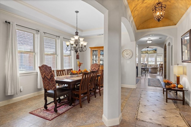 dining area with a chandelier, arched walkways, crown molding, and baseboards