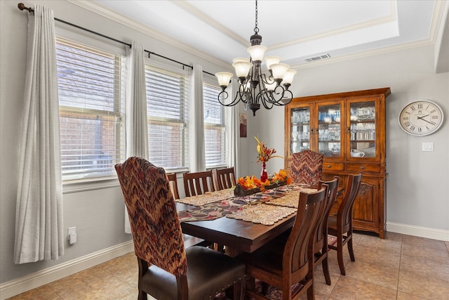 tiled dining area with a chandelier, ornamental molding, a tray ceiling, and a healthy amount of sunlight