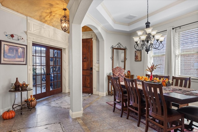 dining area featuring an inviting chandelier, arched walkways, a wealth of natural light, and french doors