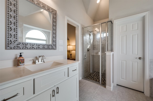 bathroom featuring tile patterned floors, vanity, vaulted ceiling, and walk in shower