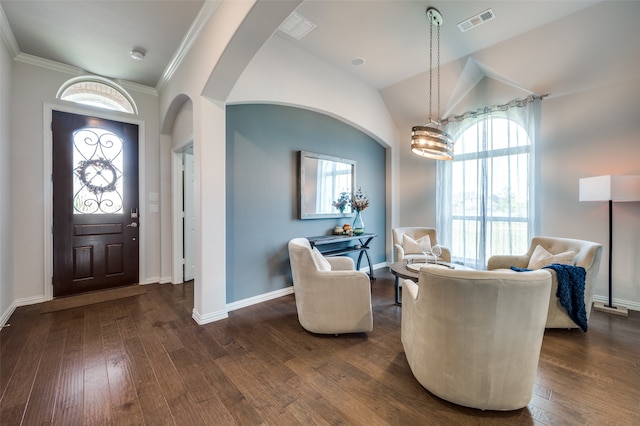 foyer with vaulted ceiling, dark hardwood / wood-style floors, an inviting chandelier, and ornamental molding