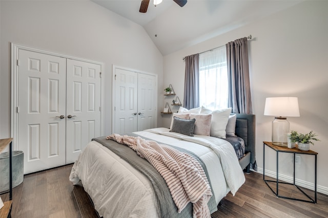 bedroom featuring two closets, ceiling fan, dark hardwood / wood-style floors, and vaulted ceiling