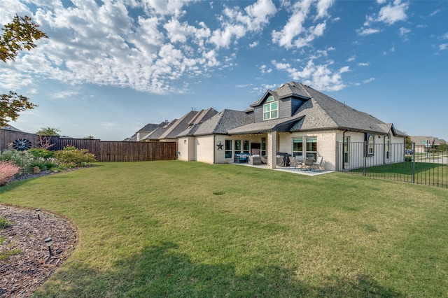 rear view of property with a patio and a lawn