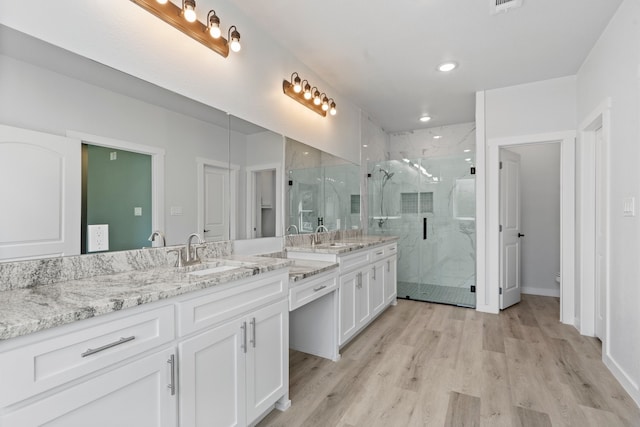 bathroom with hardwood / wood-style floors, vanity, and an enclosed shower