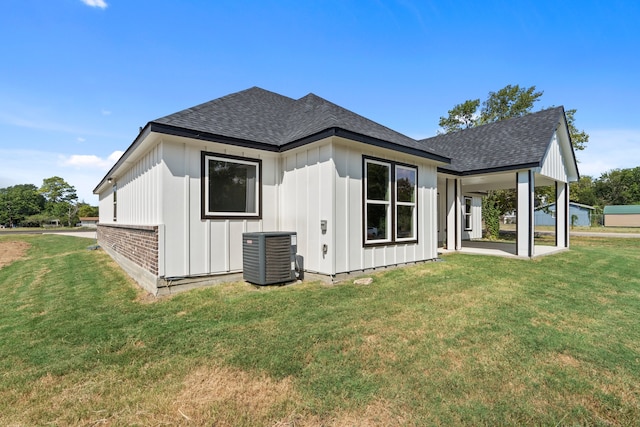 rear view of house featuring a lawn and cooling unit