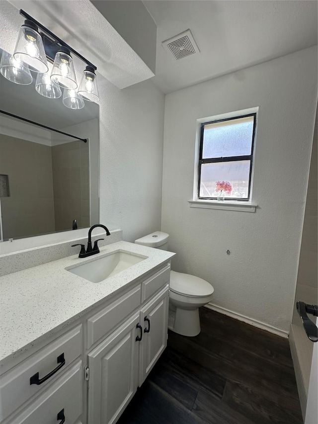 bathroom featuring vanity, hardwood / wood-style floors, toilet, and walk in shower
