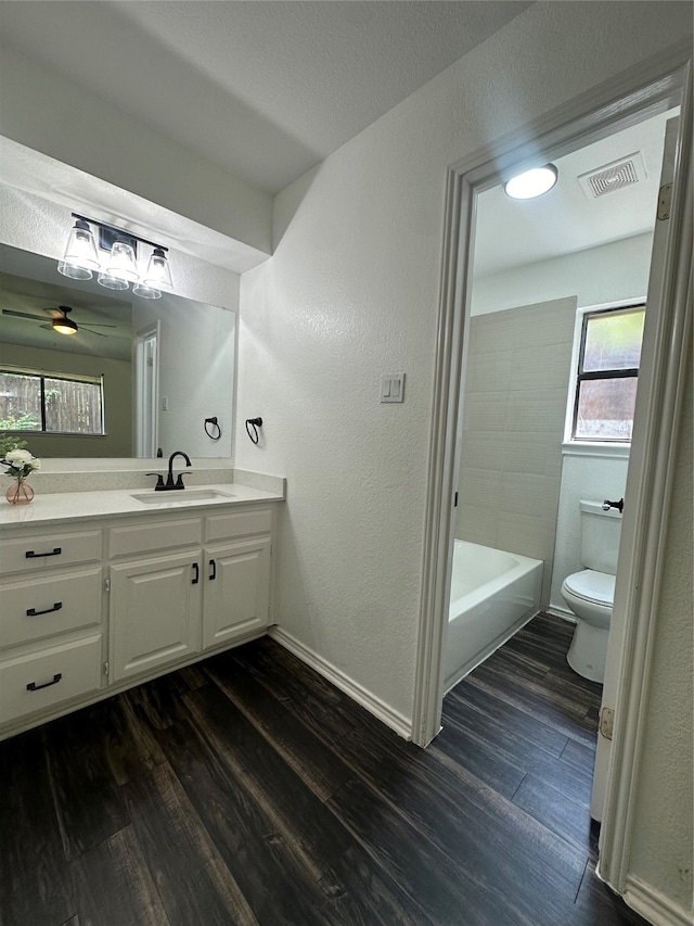 full bathroom with vanity, hardwood / wood-style floors, bathtub / shower combination, and toilet