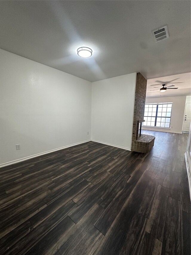spare room with dark wood-type flooring, ceiling fan, and a textured ceiling