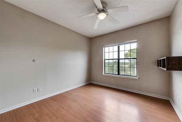 unfurnished room featuring ceiling fan, light wood-type flooring, and a textured ceiling