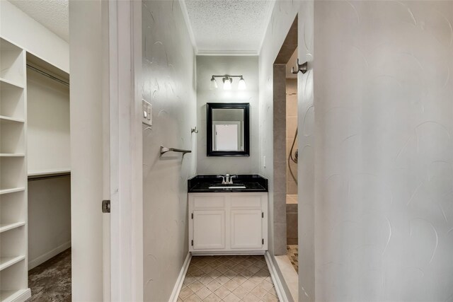 bathroom with vanity, a textured ceiling, and walk in shower