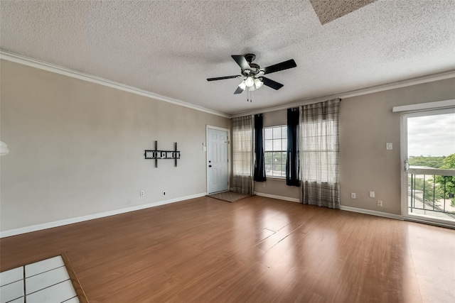 empty room with ceiling fan, hardwood / wood-style floors, a textured ceiling, and ornamental molding