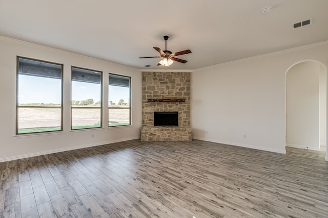 unfurnished living room with a fireplace, light wood-type flooring, ceiling fan, and crown molding