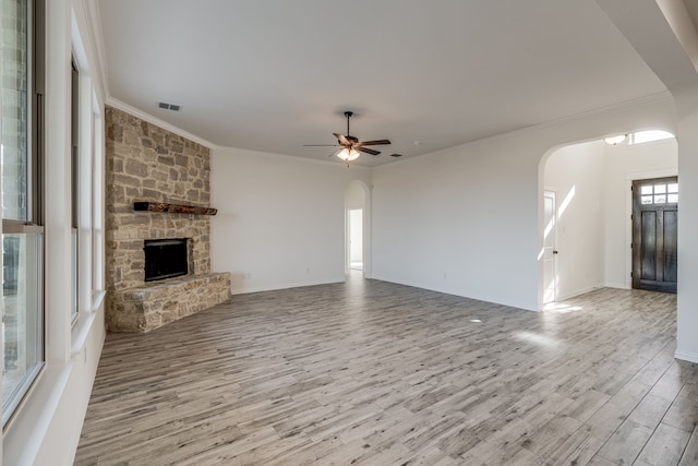 unfurnished living room with crown molding, a fireplace, ceiling fan, and light hardwood / wood-style flooring