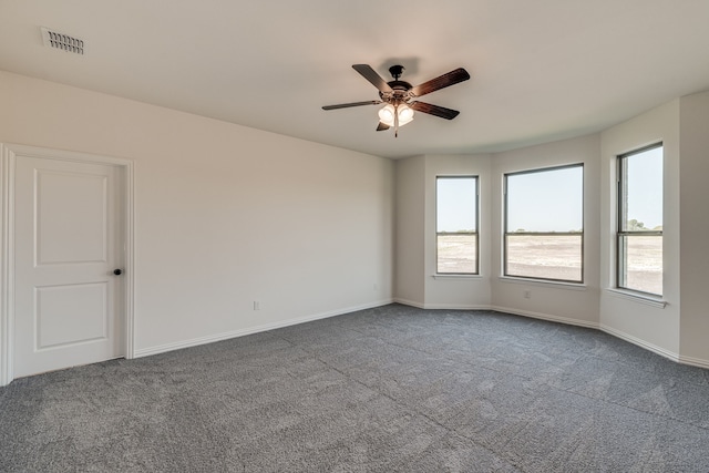 carpeted empty room featuring ceiling fan and plenty of natural light