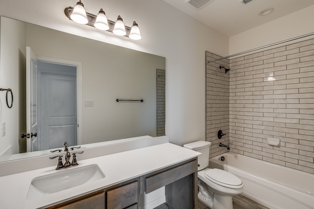 full bathroom with vanity, tiled shower / bath combo, and toilet