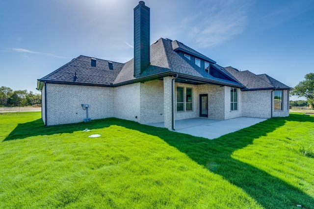 rear view of house with a patio and a lawn