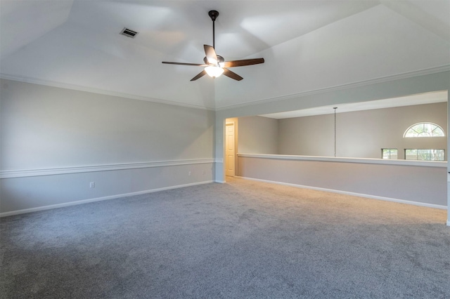 carpeted spare room with crown molding, vaulted ceiling, and ceiling fan